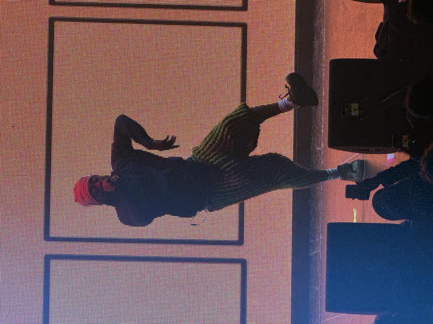 Amin&eacute; jumping on stage while performing. He's backlit by a big LED screen behind him.